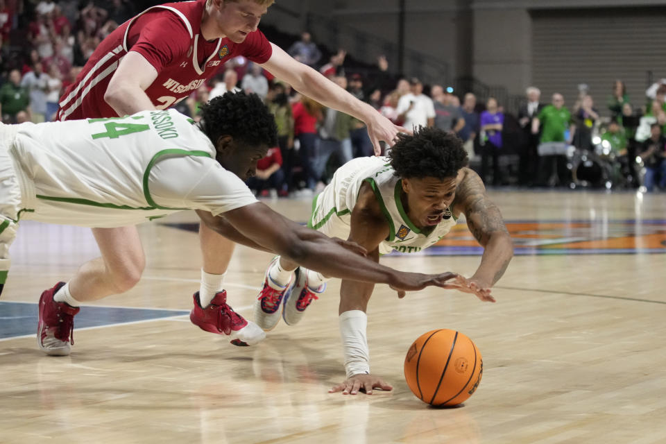 North Texas' Moulaye Sissoko, left, and North Texas' Kai Huntsberry dive towards the ball against Wisconsin during the second half of an NCAA college basketball game in the semifinals of the NIT, Tuesday, March 28, 2023, in Las Vegas. (AP Photo/John Locher)