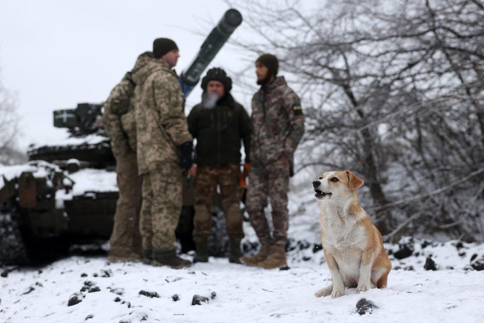 A dog sits in the snow next to a Ukrainian tank crew in a position near to the town of Bakhmut (AFP via Getty Images)