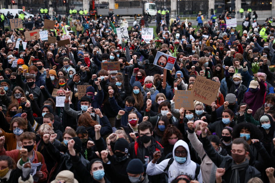 Protesters hold signs and raise their fists during the protest in Parliament Square. 