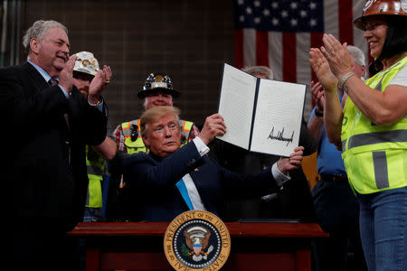 U.S. President Donald Trump displays an executive order he signed on energy and infrastructure at the International Union of Operating Engineers International Training and Education Center in Crosby, Texas, U.S., April 10, 2019. REUTERS/Carlos Barria