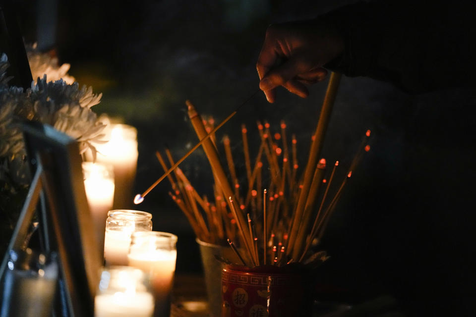 A woman lights incense during a vigil outside Monterey Park City Hall, blocks from the Star Ballroom Dance Studio, late Tuesday, Jan. 24, 2023, in Monterey Park, Calif. A gunman killed multiple people at the ballroom dance studio late Saturday amid Lunar New Year's celebrations in the predominantly Asian American community. (AP Photo/Ashley Landis)
