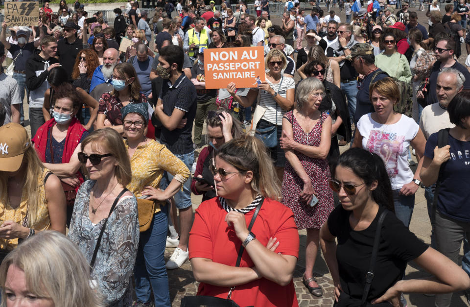 A protester holds a placard during a demonstration against the health pass, in Lille, northern France, Saturday, July 17, 2021. France announced mandatory COVID-19 passes for access to restaurants, bars, shopping malls and many tourist spots, as well as trains and planes, as of July 21. The passes are available to anyone fully vaccinated, recently recovered or who has a recent negative test. (AP Photo/Michel Spingler)