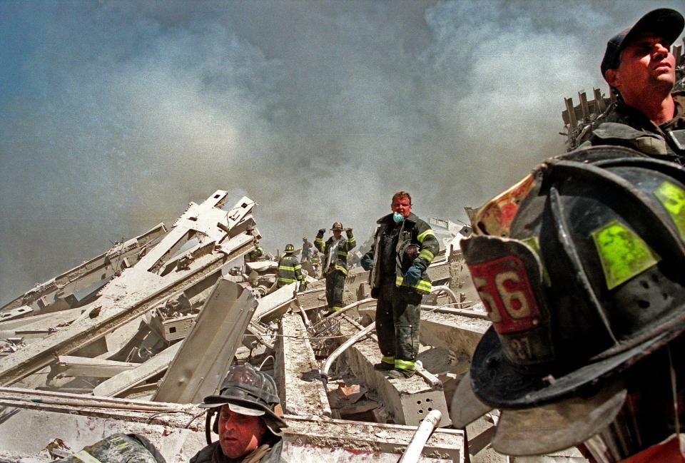 Firefighters are seen on the rubble.