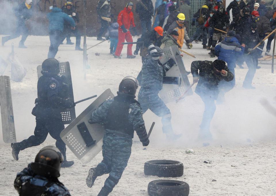 A police officer beats a protester during clashes in central Kiev, Ukraine, Wednesday, Jan. 22, 2014. Police in Ukraine's capital on Wednesday tore down protester barricades and chased demonstrators away from the site of violent clashes, hours after two protesters died after being shot, the first violent deaths in protests that are likely to drastically escalate the political crisis that has gripped Ukraine since late November. (AP Photo/Sergei Grits)