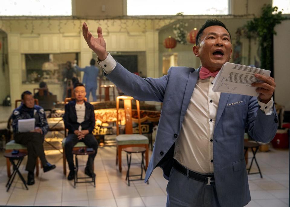 Kevin Yang makes a wide gesture while rehearsing a scene