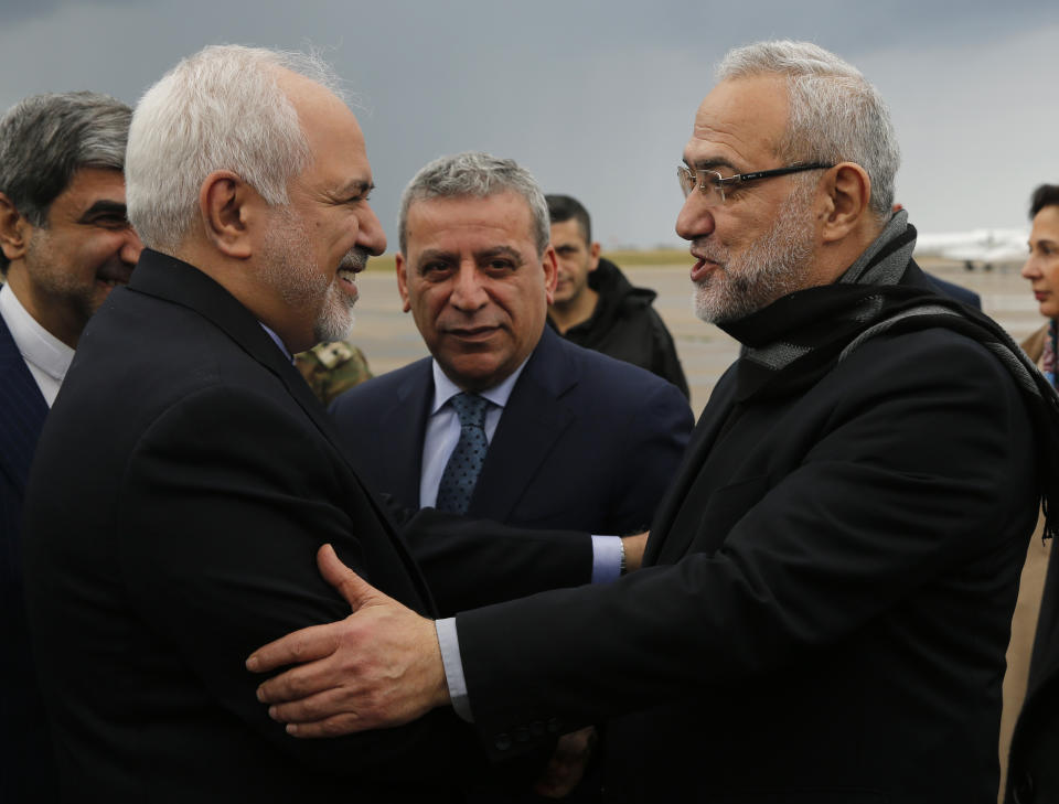 Iran's Foreign Minister Mohammad Javad Zarif, left, is greeted by Lebanese Minister of State Parliamentary Affairs and a member of Hezbollah politicians block Mahmoud Qmati, right, on his arrival at Rafik Hariri Airport, in Beirut, Lebanon, Sunday, Feb. 10, 2019. Zarif says his country is ready to cooperate with the new Lebanese government, offering his country's support in all sectors. (AP Photo/Hussein Malla)