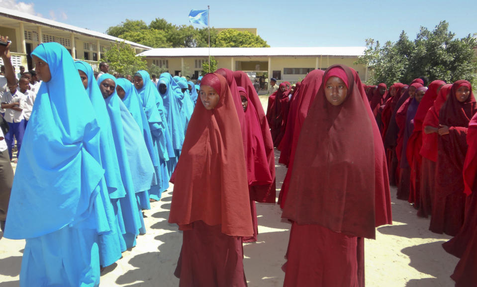 In this photo taken Wednesday, Nov. 20, 2013, Somali students line up in the courtyard of the Moalim Jama school in Mogadishu, Somalia. Officials say more than 35,000 children have been enrolled in a donor-funded program dubbed "Go2School" offering free education in Somalia since it was launched last year, proving popular with parents and children who otherwise would not go to school, but the country’s al-Qaida-linked militant group al-Shabab has issued a new threat against the program, saying it secularizes children. (AP Photo/Farah Abdi Warsameh)