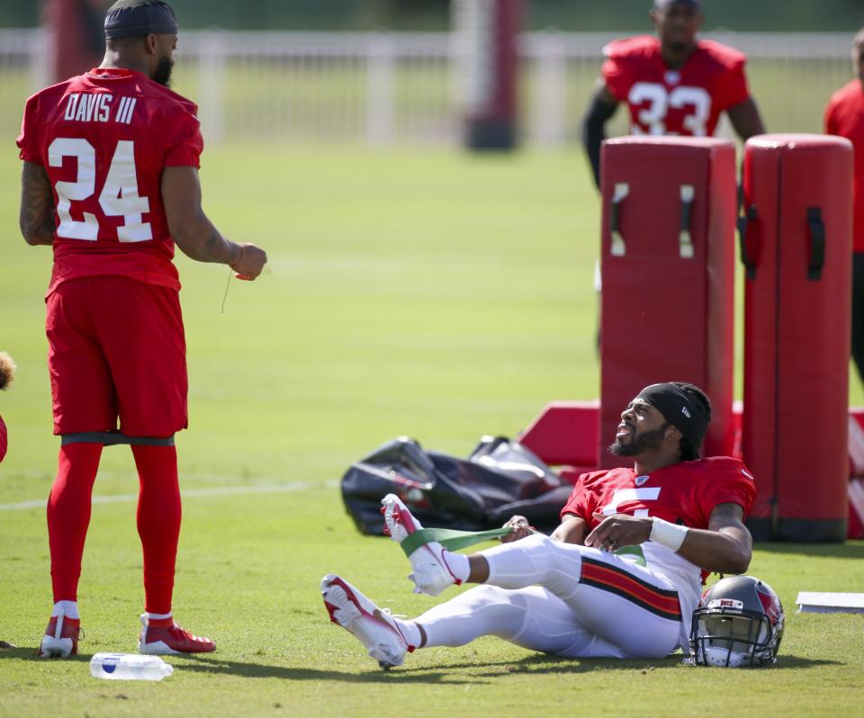 Tampa Bay Buccaneers Richard Sherman, right, stretches as he talks with teammate Carlton Davis III during an NFL football practice in Tampa, Fla., Wednesday, Sept. 29, 2021. (Chris Urso/Tampa Bay Times via AP)