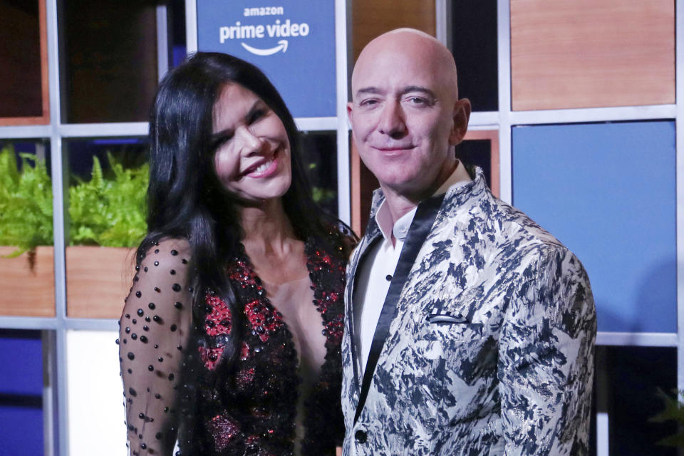 FILE - In this Jan. 16, 2020, file photo, Amazon CEO Jeff Bezos, right and his girlfriend Lauren Sanchez poses for photographs during a blue carpet event organized by Amazon Prime Video in Mumbai, India. Michael Sanchez, the brother of Jeff Bezos's girlfriend, is suing the Amazon founder for defamation, alleging that Bezos and his team falsely told reporters that he provided nude photos of Bezos to the The National Enquirer.  (AP Photo/Rafiq Maqbool, File)