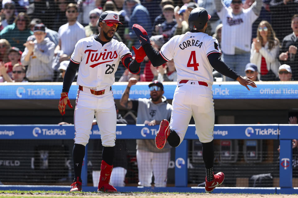 Minnesota Twins' Carlos Correa, right, scores on a triple hit by Alex Kirilloff during the first inning of a baseball game against the Cleveland Guardians, Saturday, April 6, 2024, in Minneapolis. (AP Photo/Matt Krohn)