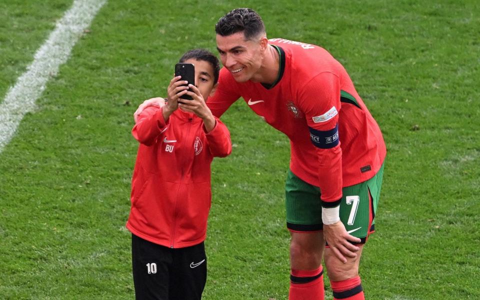 Young pitch invader takes a selfie with Portugal's Cristiano Ronaldo