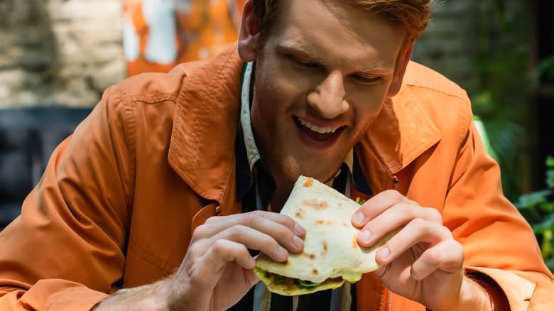 man eating quesadilla