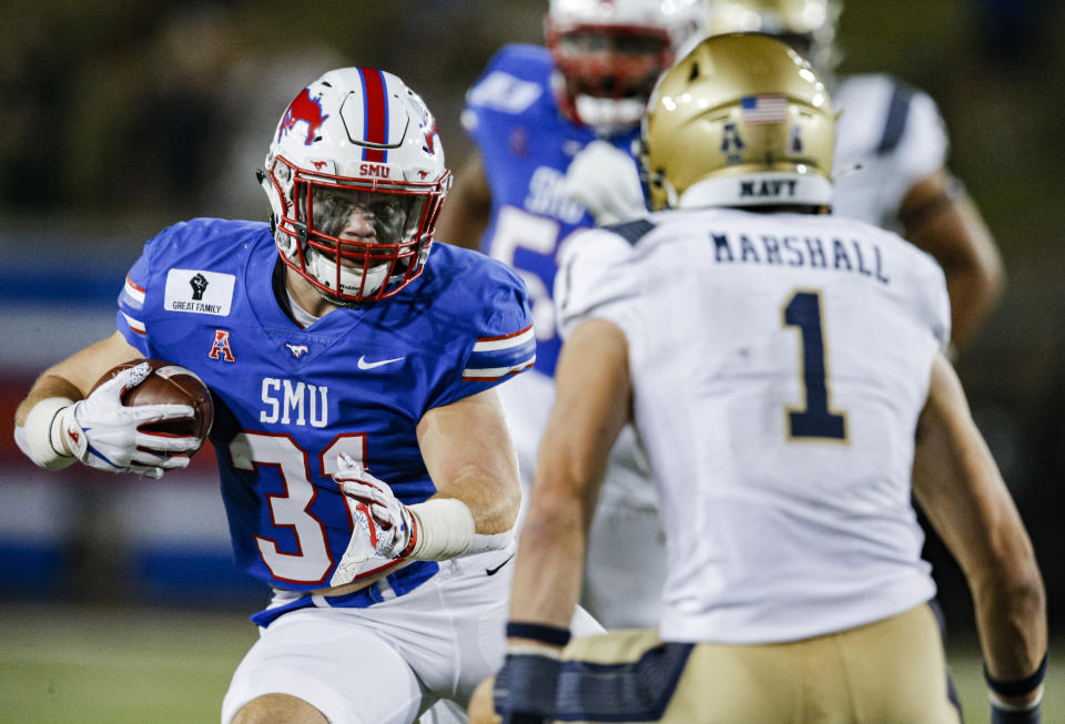 SMU running back Tyler Lavine (31) looks for room as Navy linebacker John Marshall (1) defends during the first half of an NCAA college football game Saturday, Oct. 31, 2020, in Dallas. (AP Photo/Brandon Wade)