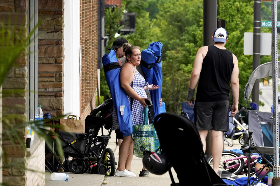 People check their belongings after a mass shooting at the Highland Park Fourth of July parade (Nam Y. Huh / AP)