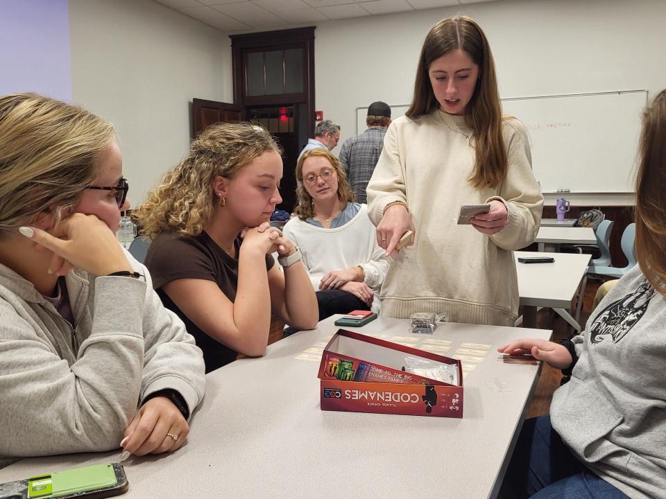 FHU senior Amelia O'Neal explains the game Codenames to her classmates following the discussion of "The Importance of Being Earnest." Codenames is a word association game that requires communication, deduction, and strategy to succeed, which has some connecting themes in "The Importance of Being Earnest."