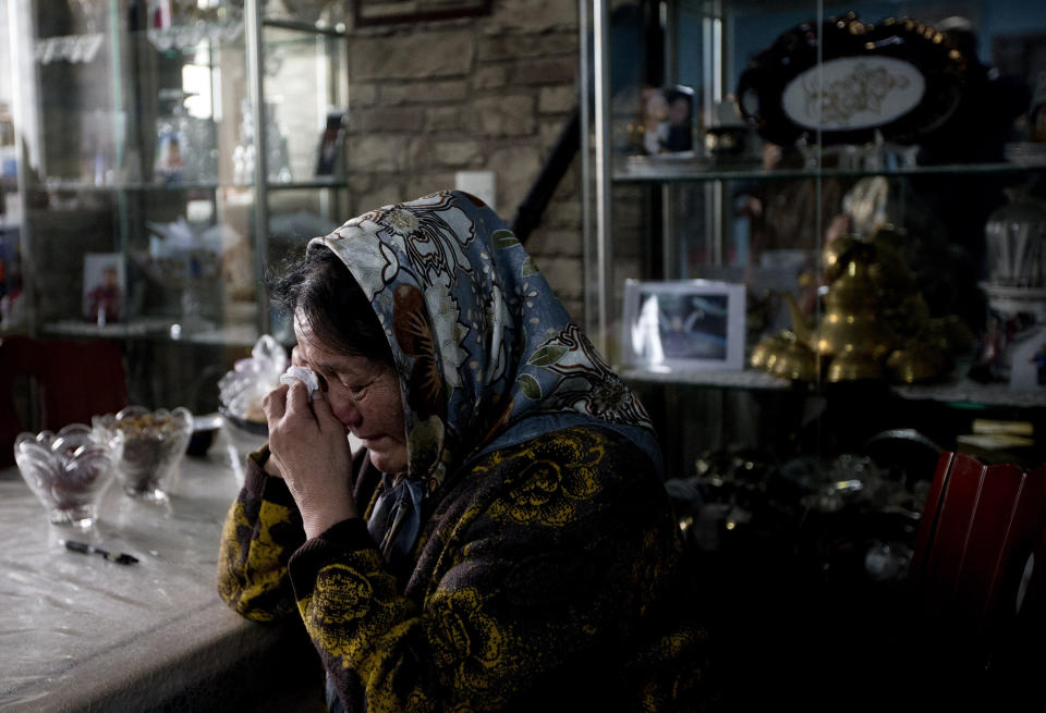 Nasipuhan, mother of Ilham Tohti cries at her son's house in Beijing Thursday, Jan. 16, 2014. Police have taken away Ilham Tohti, an outspoken scholar of China's Turkic Uighur ethnic minority and raided his home, seizing computers, cellphones and even his students' theses, his wife Guzaili Nu'er said Thursday. (AP Photo/Andy Wong)