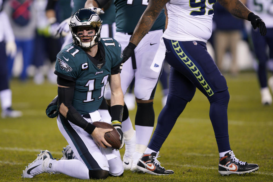 Philadelphia Eagles' Carson Wentz (11) gets up after a hit from Seattle Seahawks' Jadeveon Clowney during the first half of an NFL wild-card playoff football game, Sunday, Jan. 5, 2020, in Philadelphia. (AP Photo/Chris Szagola)