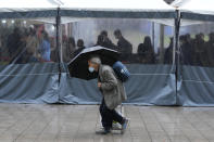 A man wearing a face mask passes by a makeshift COVID-19 testing site in Seoul, South Korea, Tuesday, Nov. 30, 2021. (AP Photo/Ahn Young-joon).