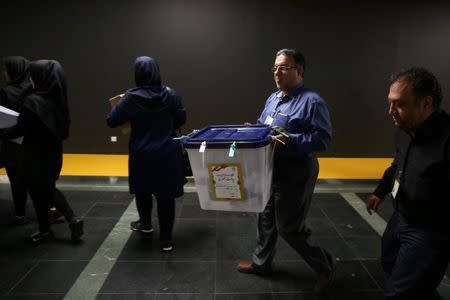 An electoral worker carries a ballot box after closing vote in a polling station in Tehran, Iran, May 19, 2017. TIMA via REUTERS