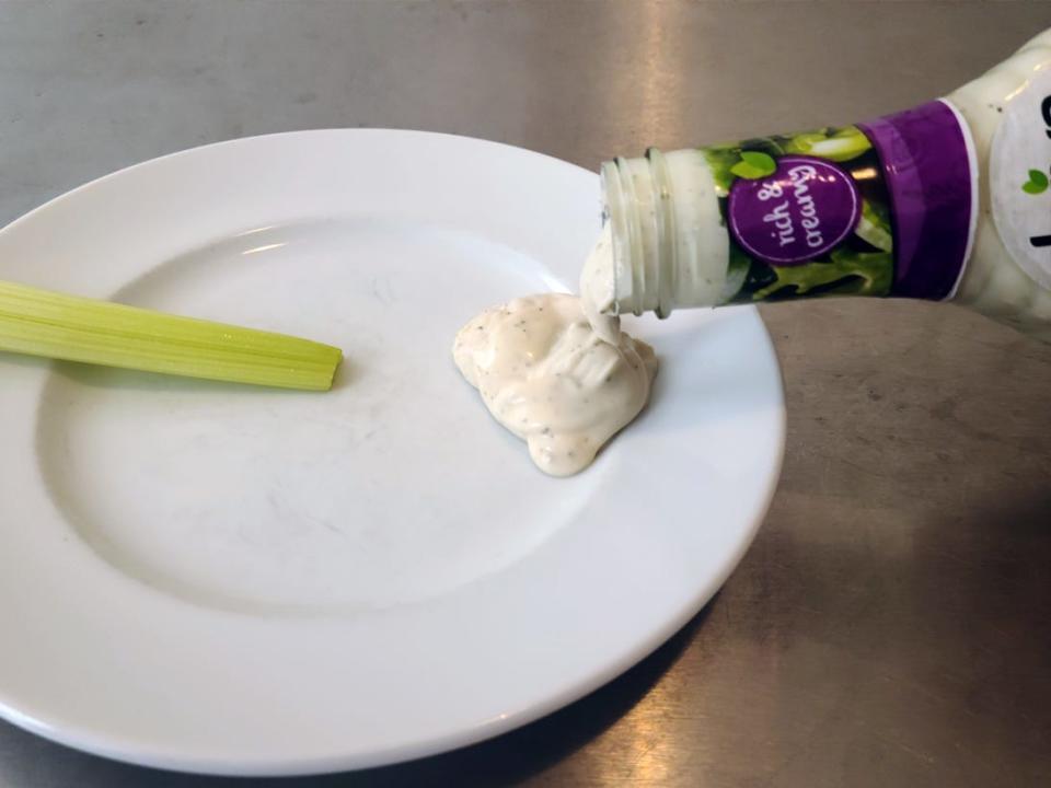 Daiya ranch dressing being poured onto a plate.