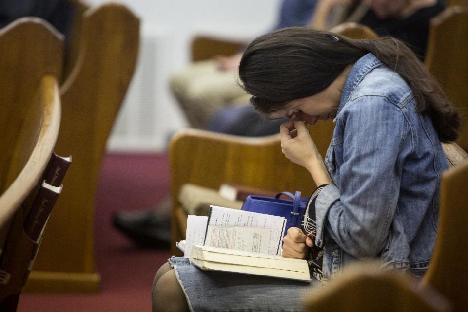 Kathy Abad, a military wife, prays for the victims and families affected by the Fort Hood shooting during a memorial service at the Tabernacle Baptist Church on Sunday, April 6, 2014, in Killeen, Texas. On April 2, 2014, three people were killed and 16 were wounded when a gunman opened fire before taking his own life at the Fort Hood military base. (AP Photo/ Tamir Kalifa)