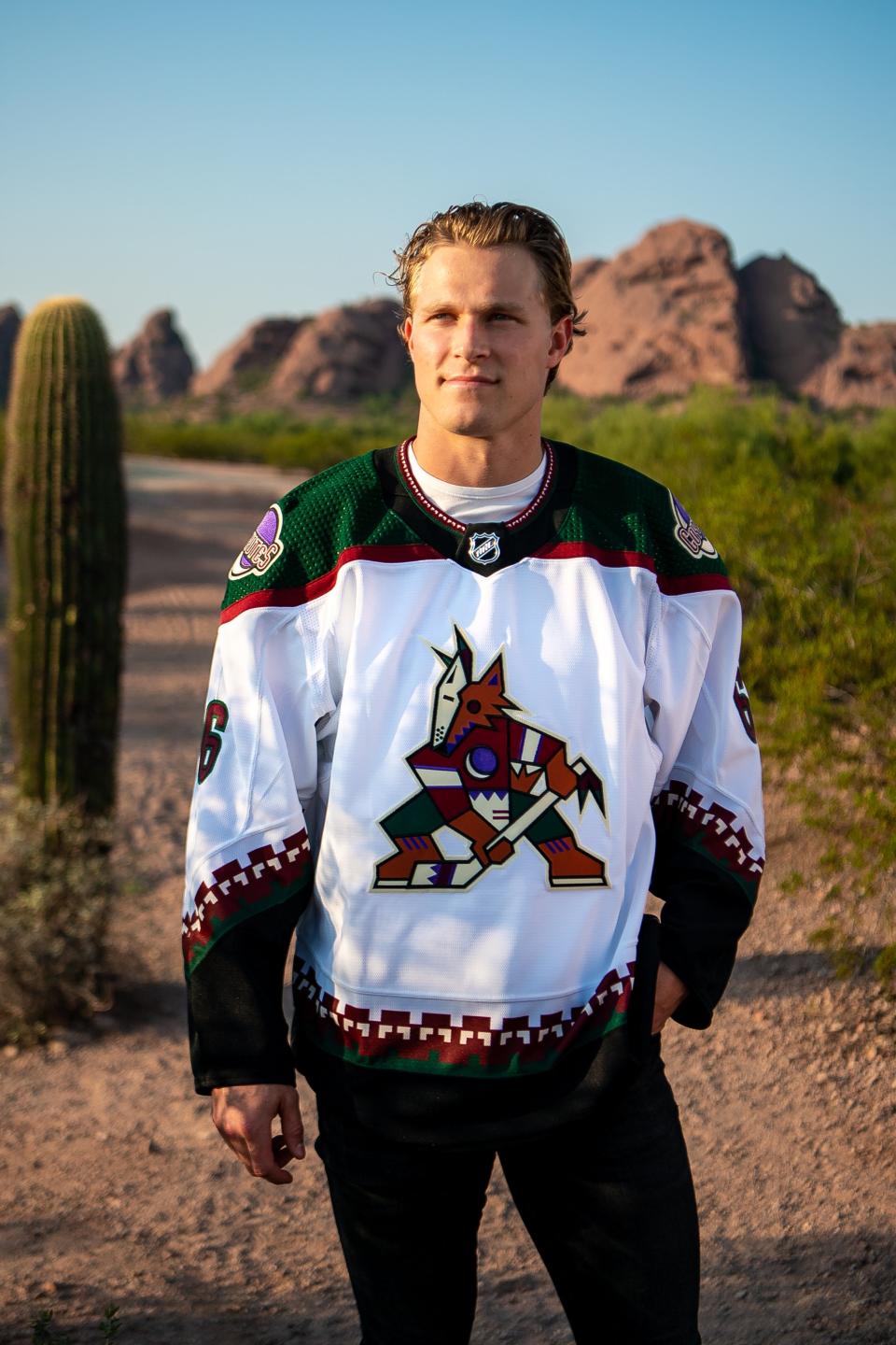 Coyotes defenseman Jakob Chychrun models the team's repurposed white road jersey with Kachina logo.