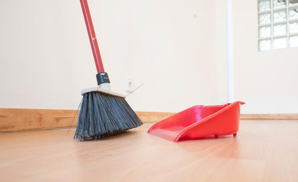 A broom and dustpan in an empty room. Moving concept (Aitor Diago / Getty Images)