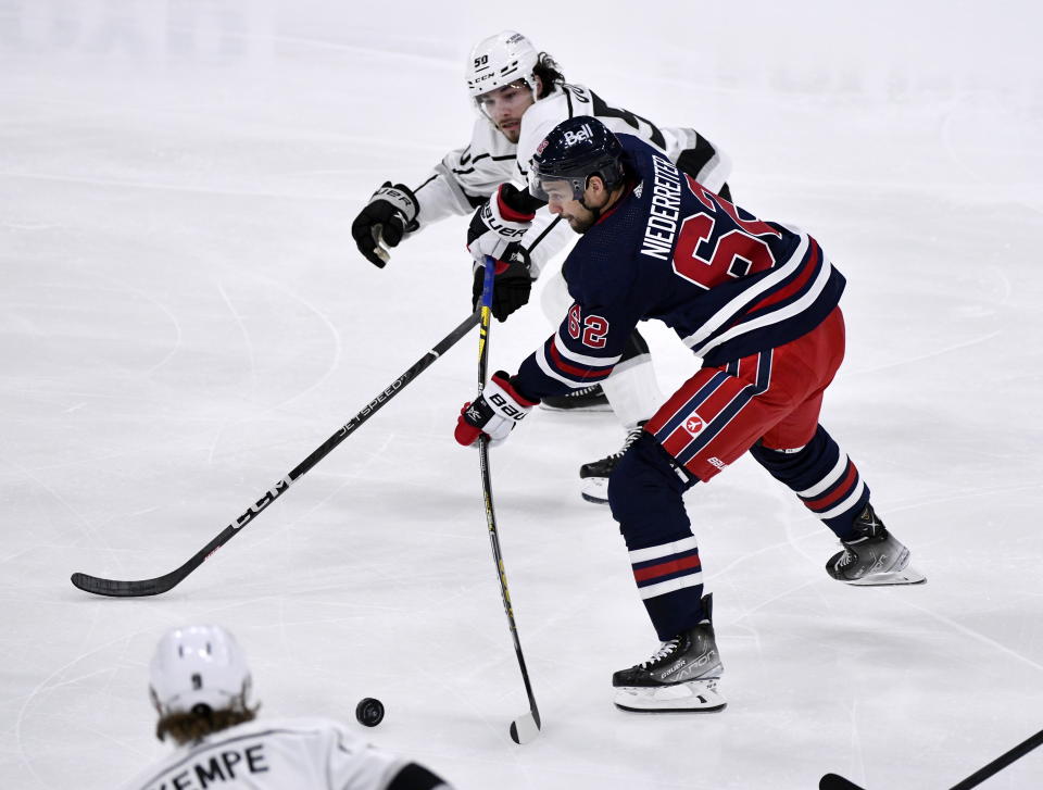 Winnipeg Jets' Nino Niederreiter takes a shot past Los Angeles Kings' Sean Durzi during the first period of an NHL hockey game in Winnipeg, Manitoba, on Tuesday, Feb. 28, 2023. (Fred Greenslade/The Canadian Press via AP)