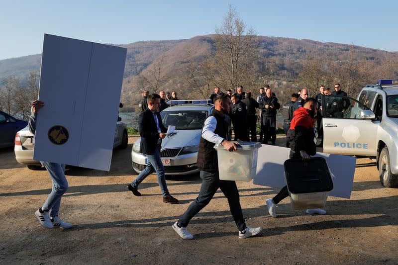 Members of the central election commission bring election items to a container used as an alternative voting center, in Zubin Potok