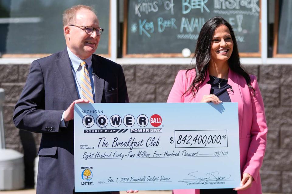 <p>Paul Sancya/AP</p> Attorney Mark K. Harder, left, representative of "The Breakfast Club," and Michigan Lottery Commissioner Suzanna Shkreli hold an an enlarged check for the $842.4 million Powerball jackpot, from the Jan. 1, 2024