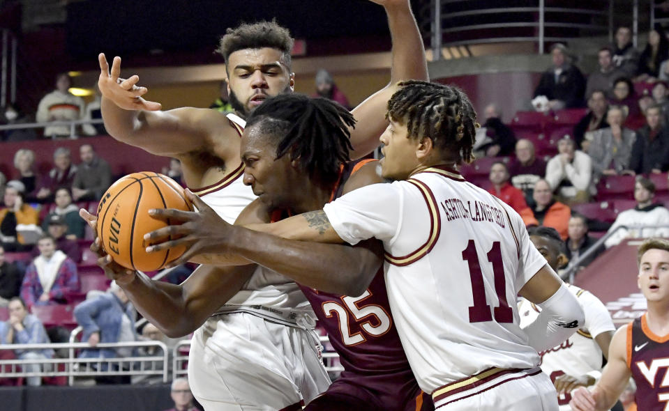 Virginia Tech's Justyn Mutts (25) is disrupted by Boston College's Makai Ashton-Langford (11) during the first half of an NCAA college basketball game, Wednesday, Dec. 21, 2022, in Boston. (AP Photo/Mark Stockwell)