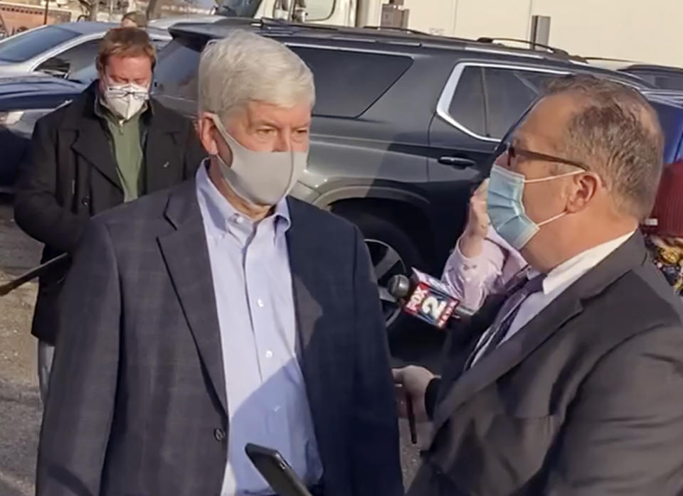 In this image taken from video, former Michigan Gov. Rick Snyder, left, with his lawyer, Brian Lennon, leave Genesee County Court in Flint, Mich., Thursday, Jan. 14, 2021, after a Zoom initial court appearance on two misdemeanor counts of willful neglect of duty in connection to the Flint water crisis. (AP Photo/Corey Williams)