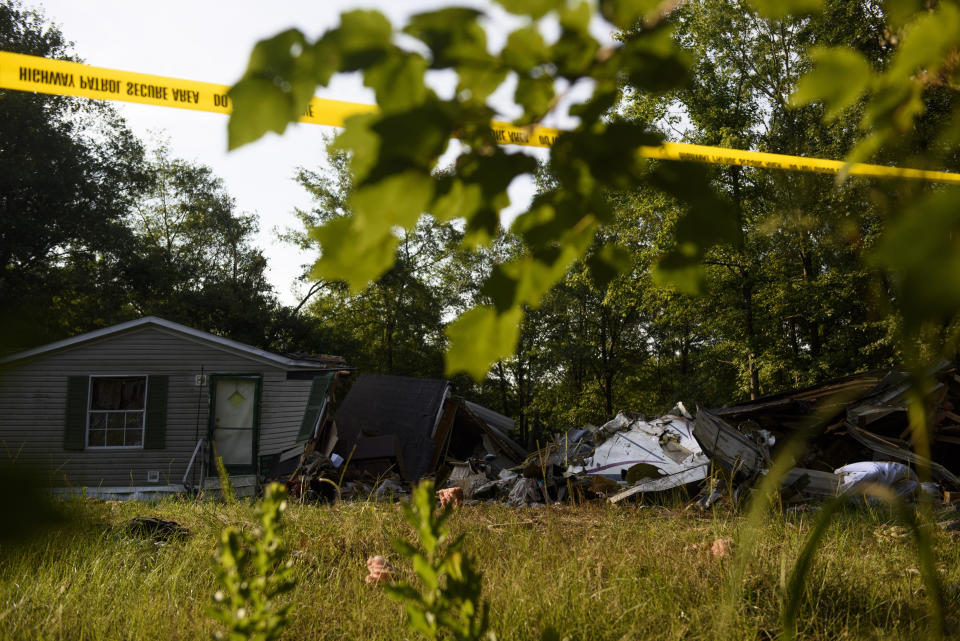Police tape is set up outside a home where a small plane had crashed into the home late Thursday evening in Hope Mills, N.C. on Friday, June 28, 2019. A single-engine plane crashed into the home, killing the pilot and someone inside the house, authorities said. Another person in the house was seriously hurt. (Melissa Sue Gerrits /The Fayetteville Observer via AP)