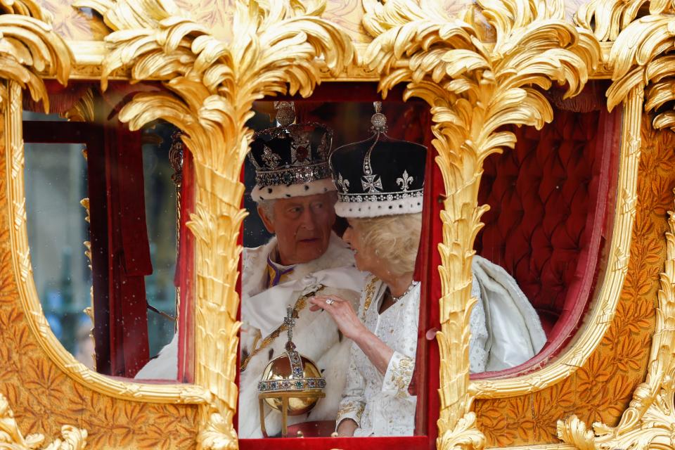 King Charles III and Queen Camilla traveling in the Gold State Coach with all of their royal regalia.