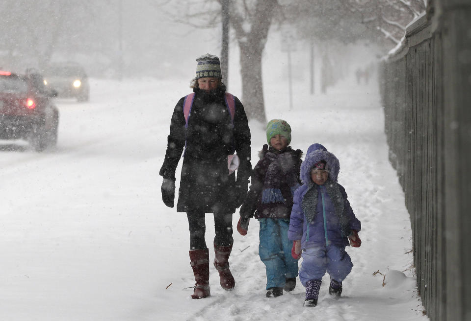 Linda Jones walks her daughters Sophie and Zoe to school as a blizzard dropped snow over Boulder, Colo., Wednesday Dec. 19, 2012. A storm that has dumped more than a foot of snow in the Rocky Mountains is heading east and is forecast to bring the first major winter storm of the season to the central plains and Midwest. (AP Photo/Brennan Linsley)