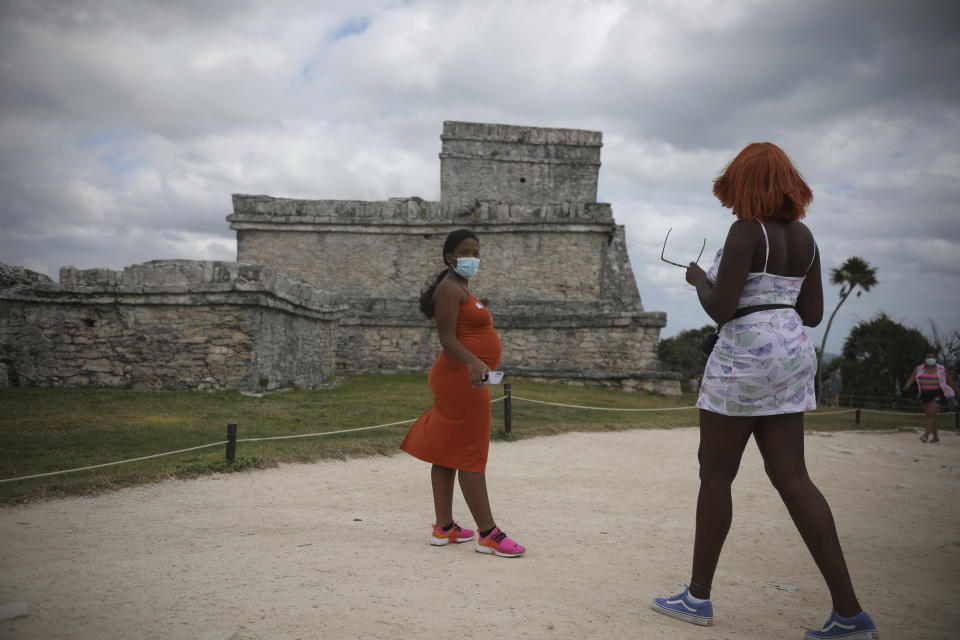 Tourists, required to wear protective face masks amid the new coronavirus pandemic, visit the Mayan ruins of Tulum in Quintana Roo state, Mexico, Tuesday, Jan. 5, 2021. Tourism accounts for 87% of Quintana Roo's gross domestic product, said state Tourism Secretary Marisol Vanegas. The state lost some 90,000 tourism jobs in the formal economy that depend on tourism due to the new coronavirus pandemic. (AP Photo/Emilio Espejel)