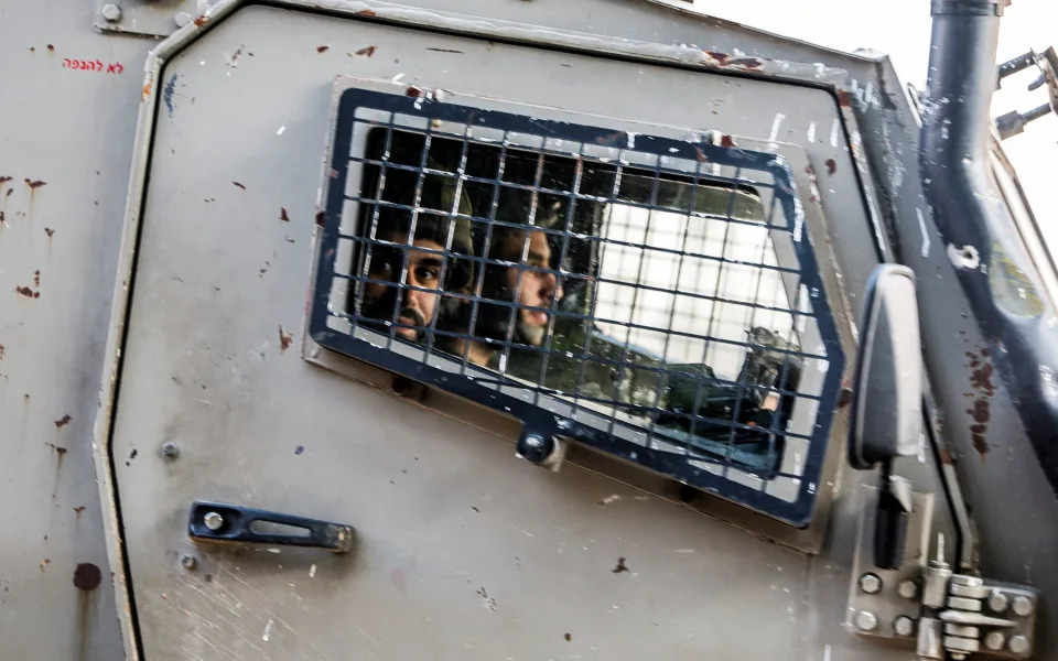 An Israeli soldier looks on from a military vehicle during a raid in Jenin