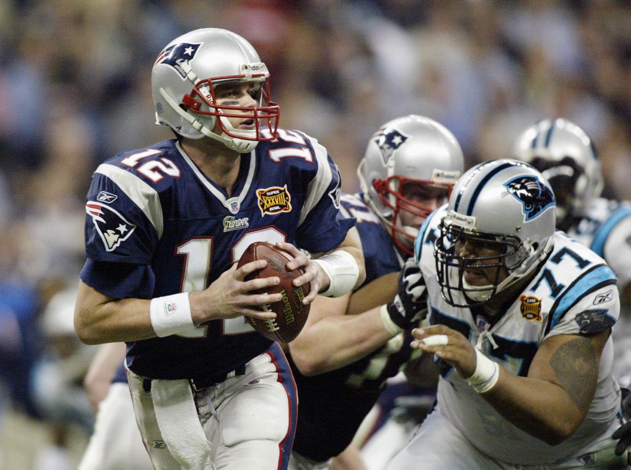 Quarterback Tom Brady #12 of the New England Patriots with the ball against the Carolina Panthers during Super Bowl XXXVIII at Reliant Stadium on February 1, 2004