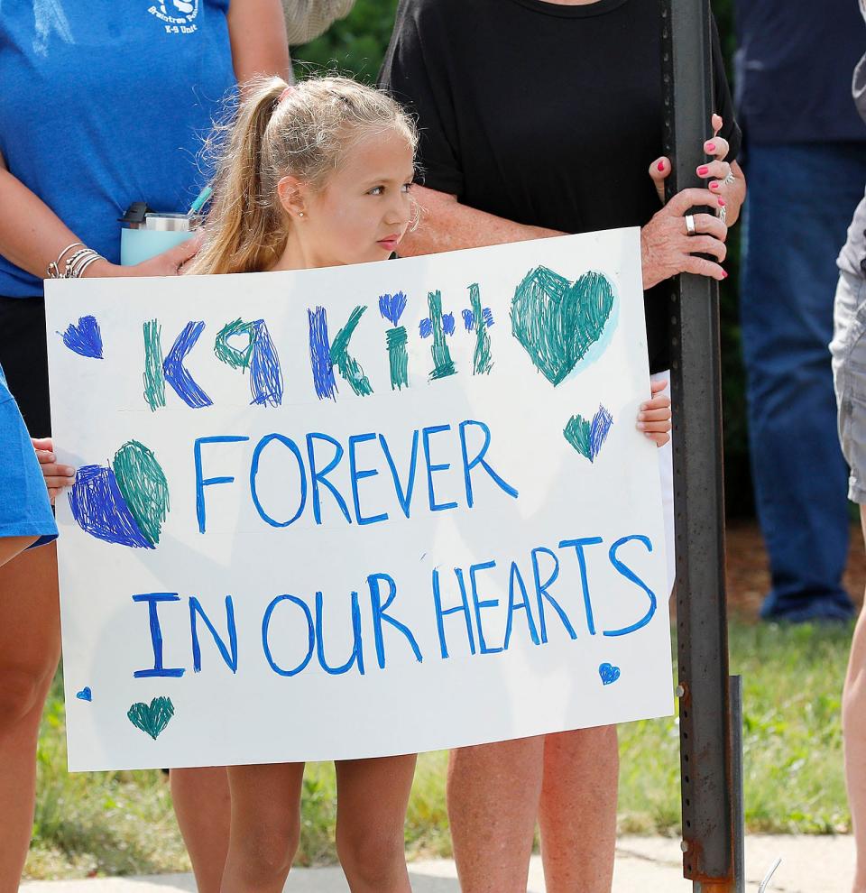 Six-year-old Brooke Wheaton made a sign to remember police dog Kitt at a funeral on June 22, 2021.