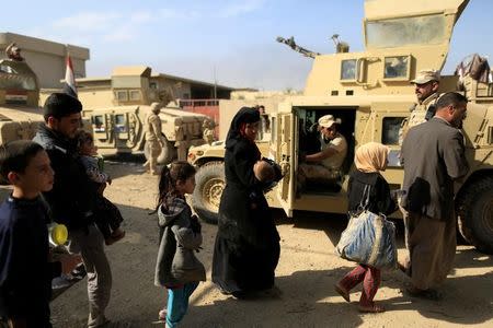 People who fled the fighting between Islamic State and Iraqi army walk beside a military Humvee near the front line in the Shahrazad disrict of eastern Mosul, Iraq, November 6, 2016. REUTERS/Zohra Bensemra