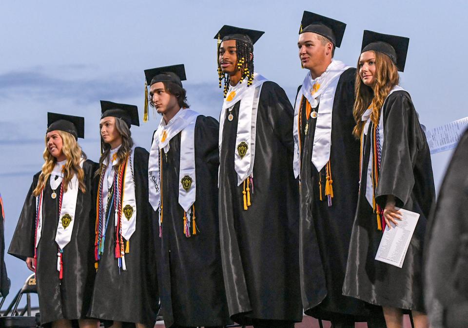 From left, Abigail Grace Rainey (Senior Class President), Allie Mikell Dickerson (Student Body Vice President), Garrett Reeves Bowen, Micah Bilal Branton, Eli Bishop (Salutatorian), and Jozie Ann Stone (Valedictorian) stand before singing the alma mater, during the Crescent High School commencement at the school stadium in Iva, S.C. Monday, May 20, 2024.