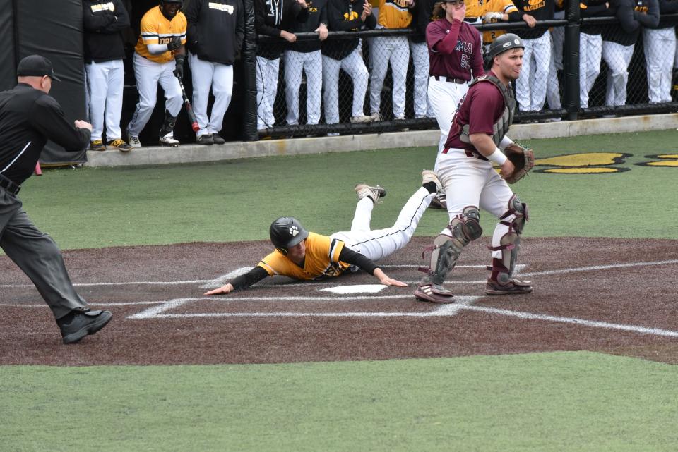 Adrian College's Ryan Davis slides across home plate during Saturday's doubleheader against Alma College.