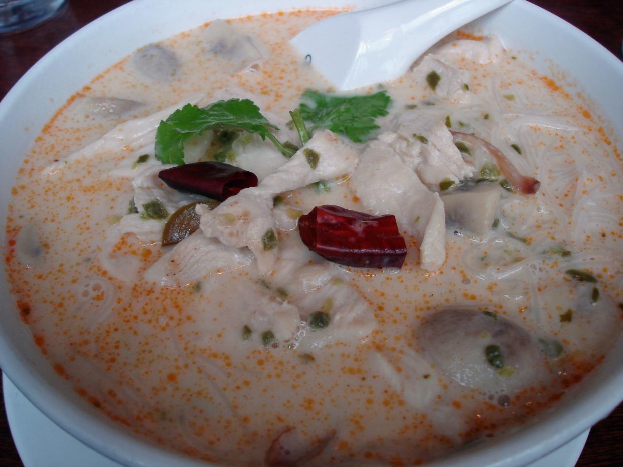 a bowl of thai tom kha soup with coconut milk