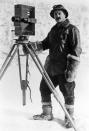 <p>English travel photographer, Herbert Ponting, poses next to his camera while on a remote winter shoot in the United Kingdom.</p>