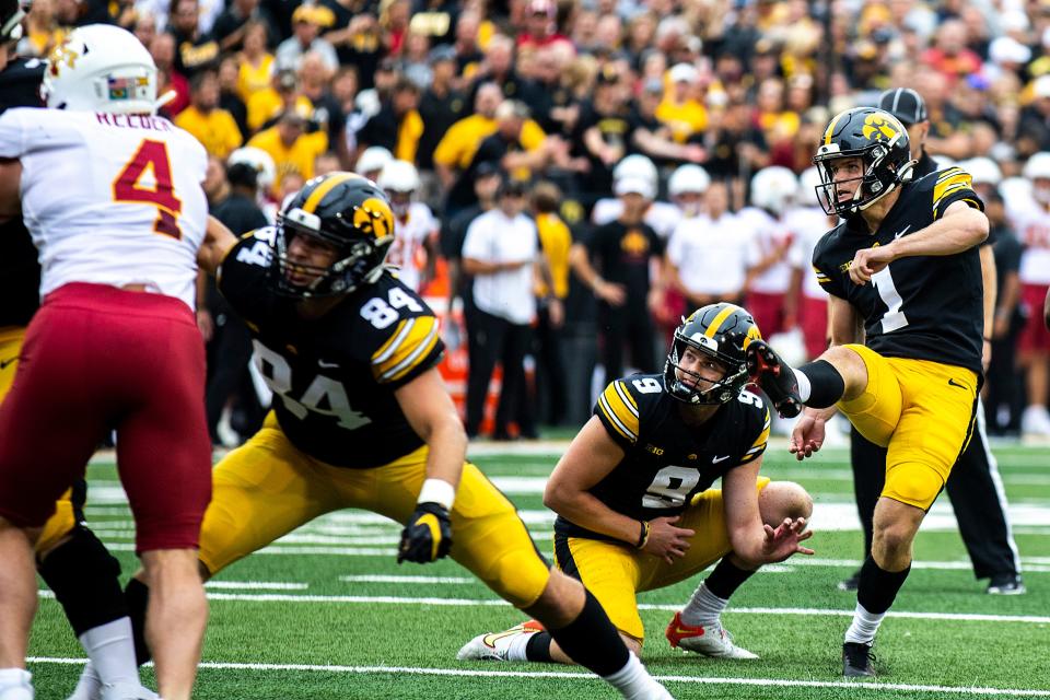 Iowa placekicker Aaron Blom, right, kicks a point after touchdown with a hold from Tory Taylor during an NCAA football game against Iowa State on Sept. 10, 2022, at Kinnick Stadium in Iowa City.