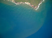 In this 2020 aerial photo provided by the Arizona State University's Global Airborne Observatory, runoff from the island of Molokai in Hawaii flows into the ocean. Recent flooding in Hawaii caused widespread and obvious damage. But extreme regional rain events that are predicted to become more common with global warming do not only wreak havoc on land, the runoff from these increasingly severe storms is also threatening Hawaii's coral reefs. (Global Airborne Observatory, Arizona State University via AP)