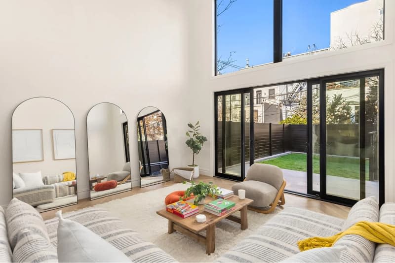 Sliding glass doors in newly renovated living room open to outdoor area.