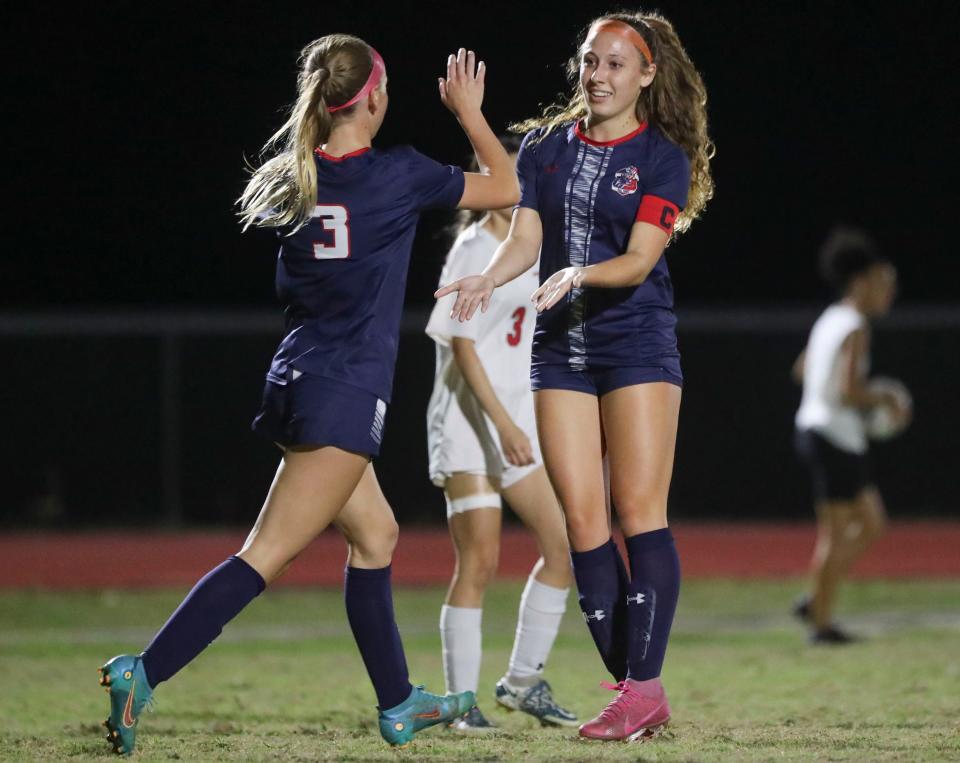 Estero Wildcats forward Kaitlyn Mancini (3) celebrates with her sister Ansley Mancini (11) after a goal during the first half of the Class 4A regional quarterfinal against the LaBelle Cowgirls at Jeff Sommer Stadium in Estero on Tuesday, Feb. 7, 2023. 