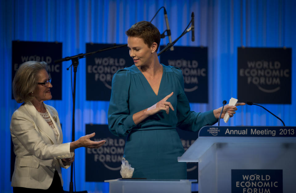 South African Academy Award-winning actress Charlize Theron, right, gestures as she accepts her Crystal award from Hilde Schwab on the eve of the opening of the 43rd Annual Meeting of the World Economic Forum, WEF, in Davos, Switzerland, Tuesday, Jan. 22, 2013. (AP Photo/Anja Niedringhaus)
