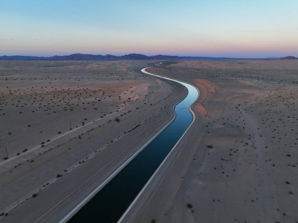 A canal cuts through empty land